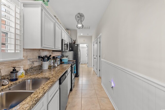 603 Wave Rider Ln Unit 603, North Myrtle Beach, SC 29582 - kitchen with appliances with stainless steel finishes, light tile patterned flooring, decorative backsplash, white cabinetry, and a sink