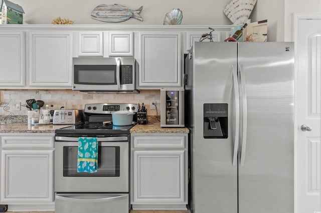 603 Wave Rider Ln Unit 603, North Myrtle Beach, SC 29582 - kitchen with appliances with stainless steel finishes, white cabinetry, and tasteful backsplash