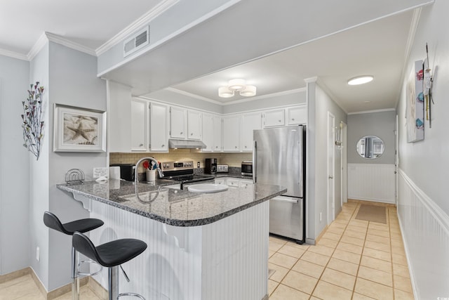 202 N Ocean Blvd Unit 109, North Myrtle Beach, SC 29582 - kitchen with appliances with stainless steel finishes, under cabinet range hood, a peninsula, light tile patterned floors, and ornamental molding