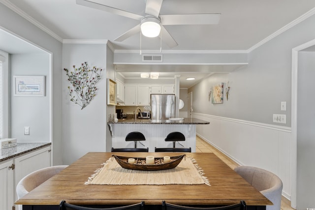 202 N Ocean Blvd Unit 109, North Myrtle Beach, SC 29582 - dining room with ceiling fan, ornamental molding, a wainscoted wall, and light tile patterned floors