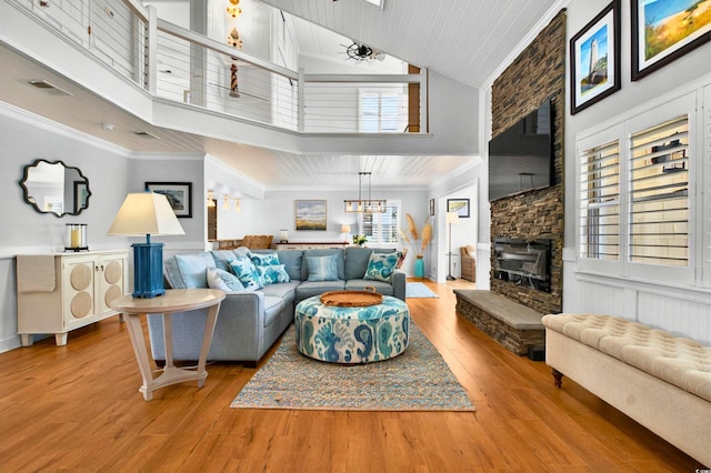 39 Newport St, Ocean Isle Beach, NC 28469 - living area with high vaulted ceiling, wood finished floors, a stone fireplace, wooden ceiling, and a chandelier