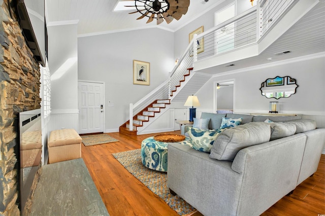 39 Newport St, Ocean Isle Beach, NC 28469 - living area with a ceiling fan, stairs, ornamental molding, wood finished floors, and a wainscoted wall