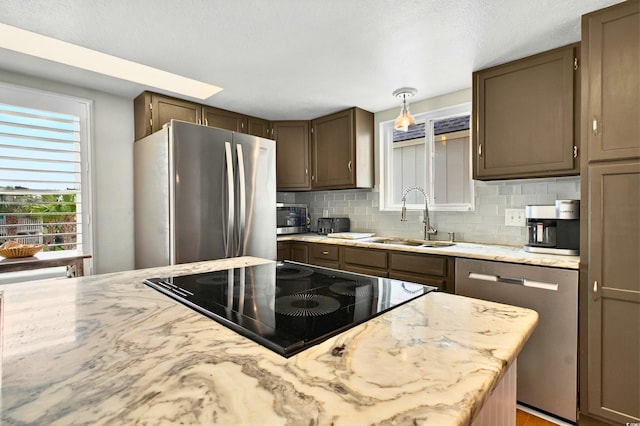 39 Newport St, Ocean Isle Beach, NC 28469 - kitchen with stainless steel appliances, a sink, backsplash, and light stone countertops