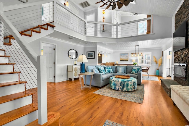 39 Newport St, Ocean Isle Beach, NC 28469 - living area with stairway, ceiling fan, high vaulted ceiling, wood finished floors, and a fireplace with raised hearth