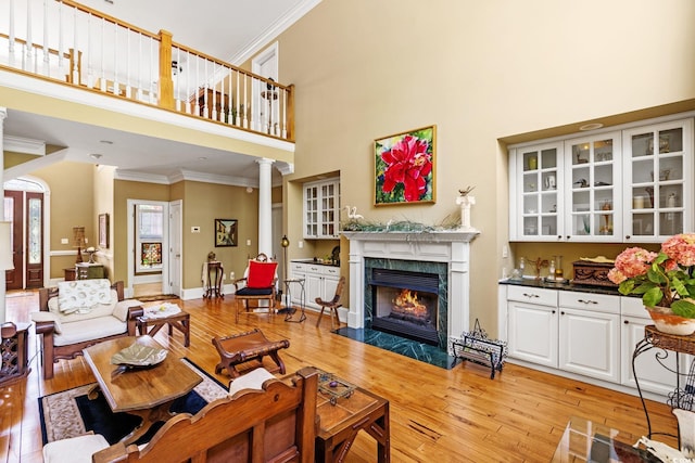 1119 Links Rd, Myrtle Beach, SC 29575 - living area with a high ceiling, ornamental molding, light wood-type flooring, a premium fireplace, and decorative columns