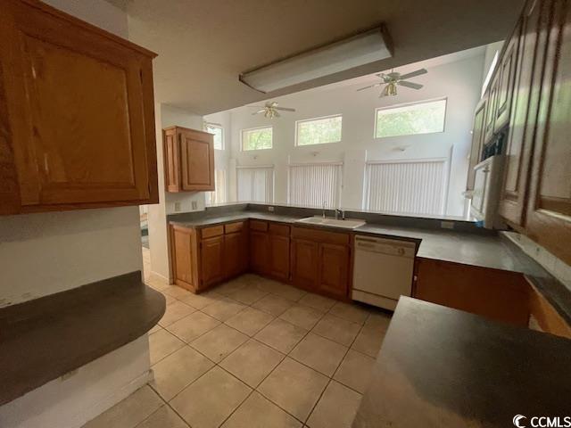 2862 Loblolly Ave, Little River, SC 29566 - kitchen with dishwasher, ceiling fan, brown cabinetry, light tile patterned floors, and a sink