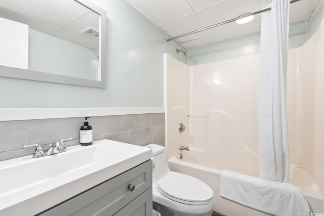 201 74th Ave N Unit 2243/2244, Myrtle Beach, SC 29572 - bathroom with shower / bathtub combination with curtain, toilet, vanity, tile walls, and a wainscoted wall