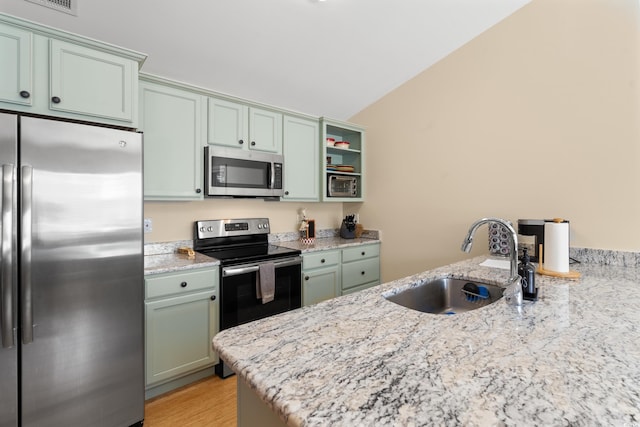 3721 Ed Smith Ave, Myrtle Beach, SC 29588 - kitchen featuring stainless steel appliances, a sink, vaulted ceiling, light stone counters, and a peninsula