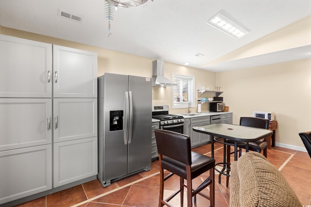 3721 Ed Smith Ave, Myrtle Beach, SC 29588 - kitchen featuring stainless steel appliances, wall chimney exhaust hood, a sink, tile patterned flooring, and vaulted ceiling