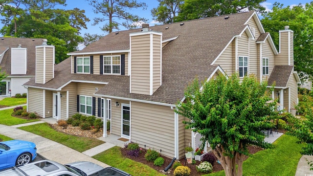 503 20th Ave N Unit 55B, North Myrtle Beach, SC 29582 - view of front of property with a chimney, roof with shingles, and uncovered parking