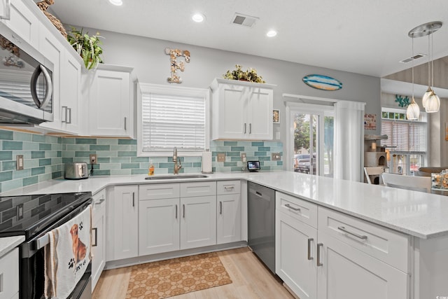 503 20th Ave N Unit 55B, North Myrtle Beach, SC 29582 - kitchen with a sink, appliances with stainless steel finishes, a peninsula, white cabinetry, and recessed lighting