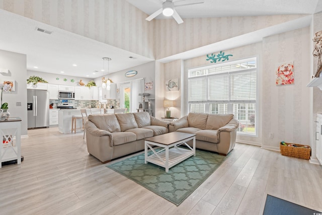 503 20th Ave N Unit 55B, North Myrtle Beach, SC 29582 - living area featuring wallpapered walls, light wood-type flooring, a towering ceiling, a ceiling fan, and baseboards