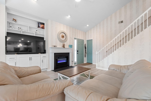 503 20th Ave N Unit 55B, North Myrtle Beach, SC 29582 - living room featuring wallpapered walls, stairs, wood finished floors, a fireplace with flush hearth, and baseboards