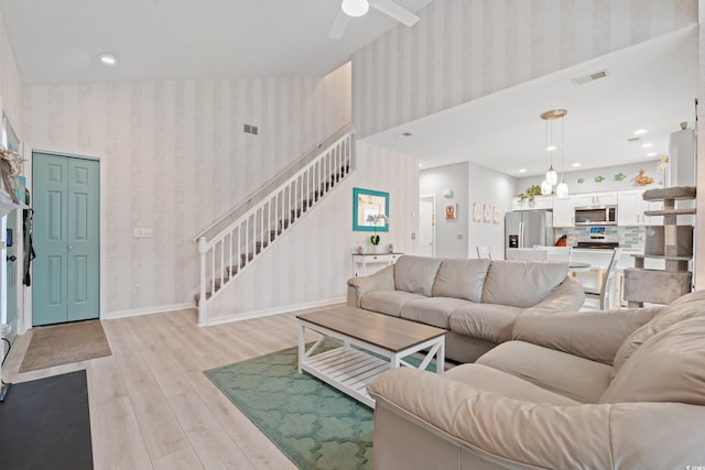 503 20th Ave N Unit 55B, North Myrtle Beach, SC 29582 - living room featuring wallpapered walls, light wood finished floors, stairs, a ceiling fan, and baseboards