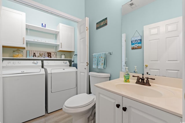 503 20th Ave N Unit 55B, North Myrtle Beach, SC 29582 - bathroom with independent washer and dryer, vanity, toilet, and wood finished floors