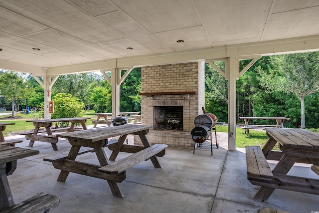 24 Willowbend Dr, Murrells Inlet, SC 29576 - view of patio featuring an outdoor brick fireplace and view of wooded area