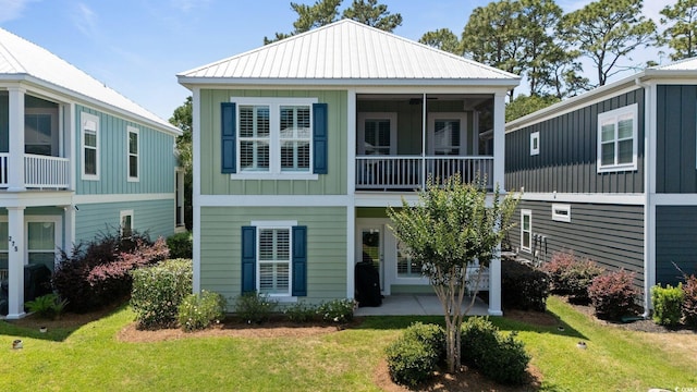 281 Lumbee Cir, Pawleys Island, SC 29585 - view of front of house with board and batten siding, a front yard, a patio, and metal roof