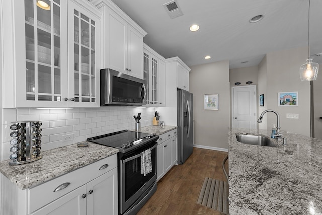 281 Lumbee Cir, Pawleys Island, SC 29585 - kitchen featuring stainless steel appliances, a sink, white cabinets, dark wood-type flooring, and decorative backsplash