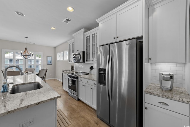281 Lumbee Cir, Pawleys Island, SC 29585 - kitchen with stainless steel appliances, a sink, white cabinets, decorative backsplash, and recessed lighting