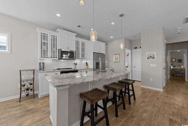 281 Lumbee Cir, Pawleys Island, SC 29585 - kitchen featuring appliances with stainless steel finishes, an island with sink, decorative backsplash, baseboards, and recessed lighting