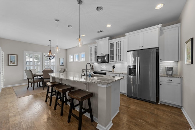 281 Lumbee Cir, Pawleys Island, SC 29585 - kitchen with stainless steel appliances, a center island with sink, decorative backsplash, a breakfast bar area, and recessed lighting