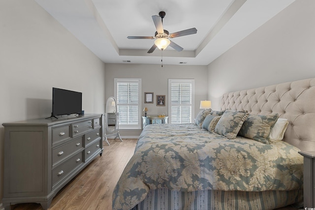 281 Lumbee Cir, Pawleys Island, SC 29585 - bedroom featuring a tray ceiling, wood finished floors, a ceiling fan, and baseboards