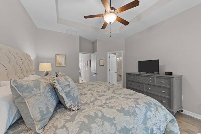 281 Lumbee Cir, Pawleys Island, SC 29585 - bedroom with wood finished floors, a raised ceiling, baseboards, a ceiling fan, and ensuite bath
