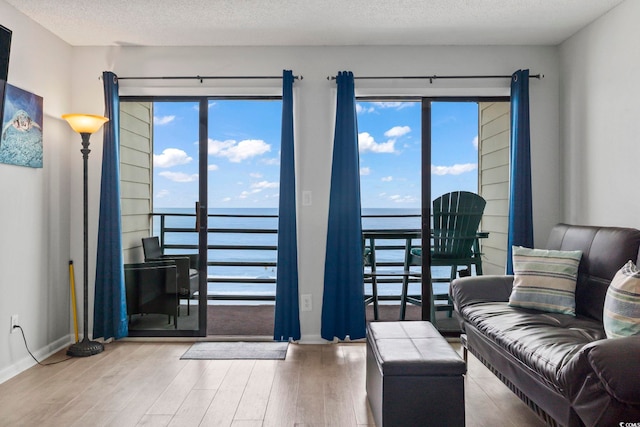 920 N Waccamaw Dr Unit 1302, Garden City Beach, SC 29576 - living area with wood finished floors, a water view, baseboards, and a textured ceiling