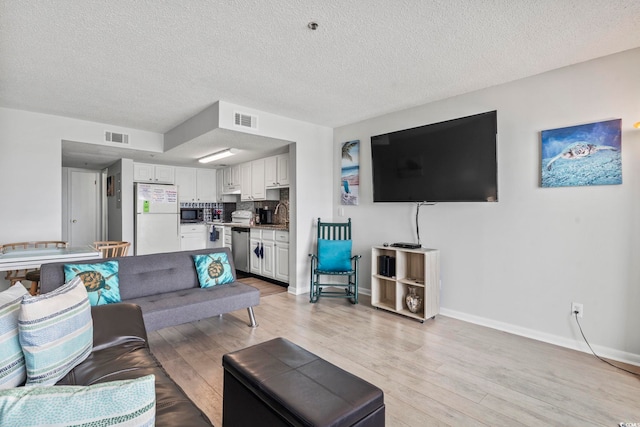 920 N Waccamaw Dr Unit 1302, Garden City Beach, SC 29576 - living area with a textured ceiling, light wood-type flooring, and baseboards