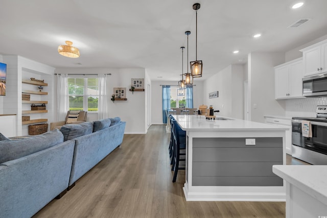 553 Pier Ct, Little River, SC 29566 - kitchen featuring stainless steel appliances, open floor plan, light countertops, white cabinetry, and healthy amount of natural light