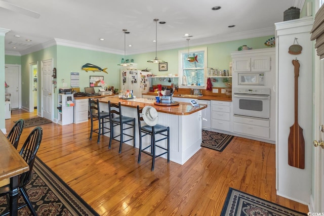 3926 Flagg St, Murrells Inlet, SC 29576 - kitchen with white appliances, white cabinets, butcher block counters, light wood-style flooring, and recessed lighting