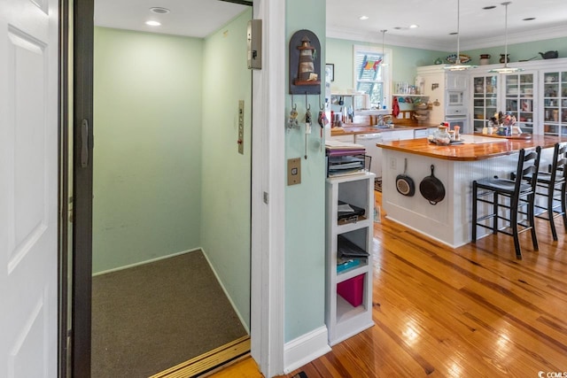 3926 Flagg St, Murrells Inlet, SC 29576 - kitchen with butcher block countertops, elevator, white appliances, ornamental molding, and a breakfast bar area