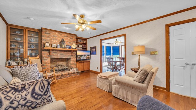 412 Carolina Dr, Loris, SC 29569 - living room with a ceiling fan, a brick fireplace, light wood-style floors, and crown molding