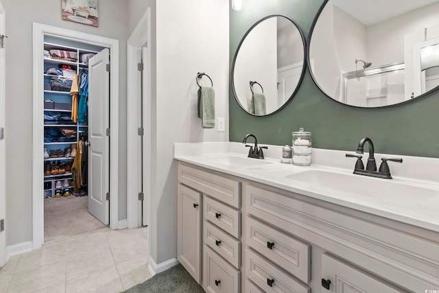 4927 Sandlewood Dr, Myrtle Beach, SC 29579 - bathroom with double vanity, a walk in closet, baseboards, and tile patterned floors