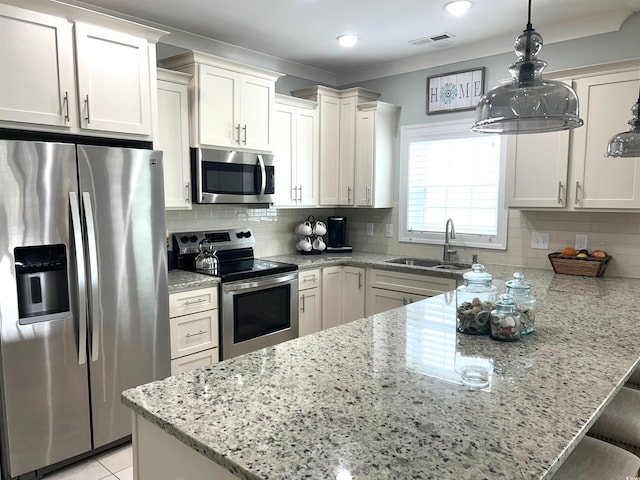 1029 Ray Costin Way Unit 909, Murrells Inlet, SC 29576 - kitchen featuring appliances with stainless steel finishes, a sink, a peninsula, light stone countertops, and white cabinetry