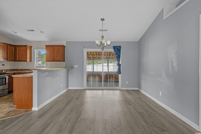 1220 Dunraven Ct, Conway, SC 29527 - kitchen with stainless steel electric range, wood finished floors, a chandelier, and brown cabinets