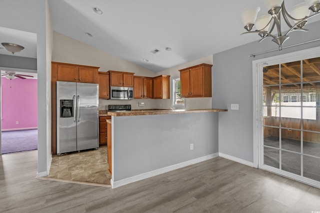1220 Dunraven Ct, Conway, SC 29527 - kitchen with appliances with stainless steel finishes, vaulted ceiling, light wood-style floors, brown cabinets, and a ceiling fan