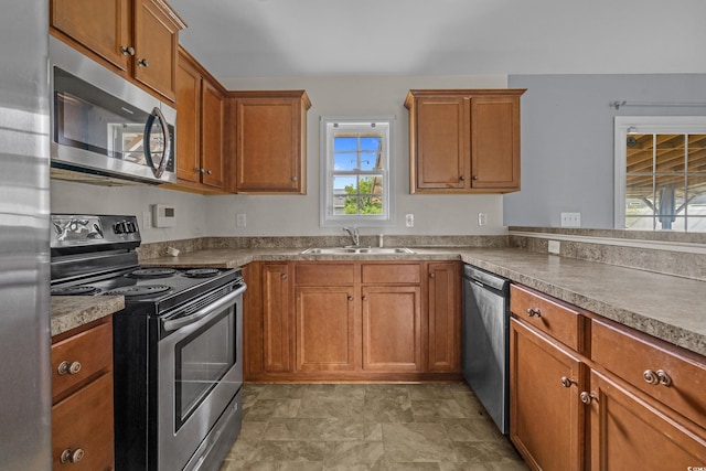 1220 Dunraven Ct, Conway, SC 29527 - kitchen with appliances with stainless steel finishes, a sink, healthy amount of natural light, and brown cabinetry