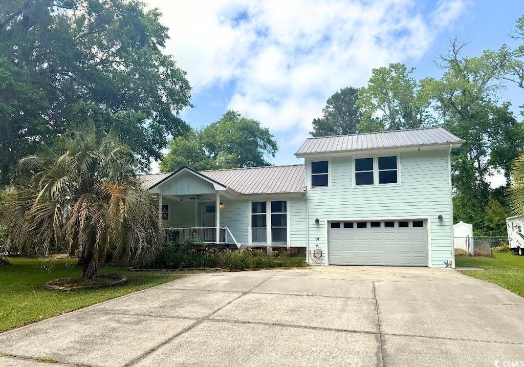 3670 Earls Rd, Myrtle Beach, SC 29588 - view of front of house featuring a garage, a porch, driveway, and metal roof