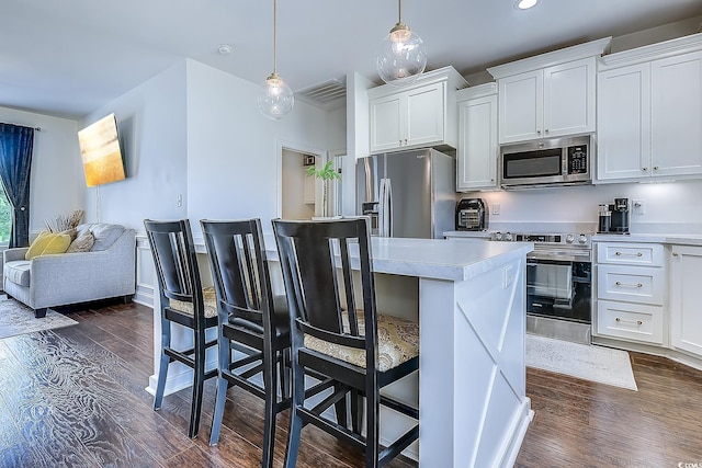 548 Fox Chase Dr, Conway, SC 29527 - kitchen featuring appliances with stainless steel finishes, dark wood-type flooring, light countertops, white cabinets, and a breakfast bar