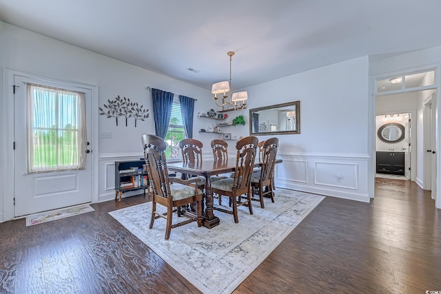 548 Fox Chase Dr, Conway, SC 29527 - dining room with stacked washing machine and dryer, a chandelier, a wainscoted wall, dark wood finished floors, and a decorative wall