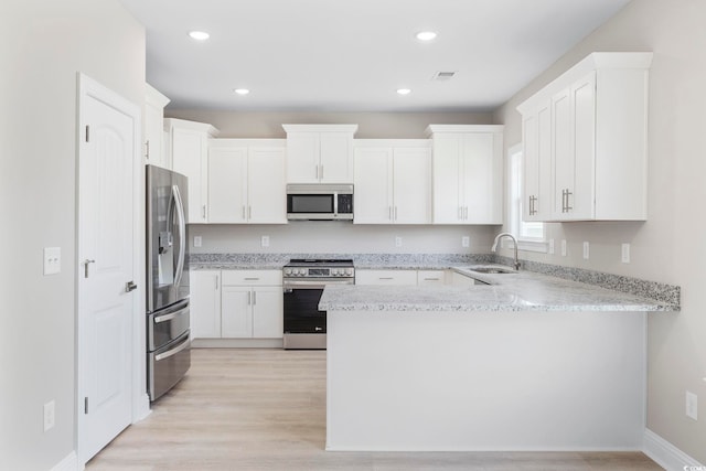 1900 Blue Bird Rd, Loris, SC 29569 - kitchen with a peninsula, stainless steel appliances, white cabinets, light wood-style floors, and recessed lighting