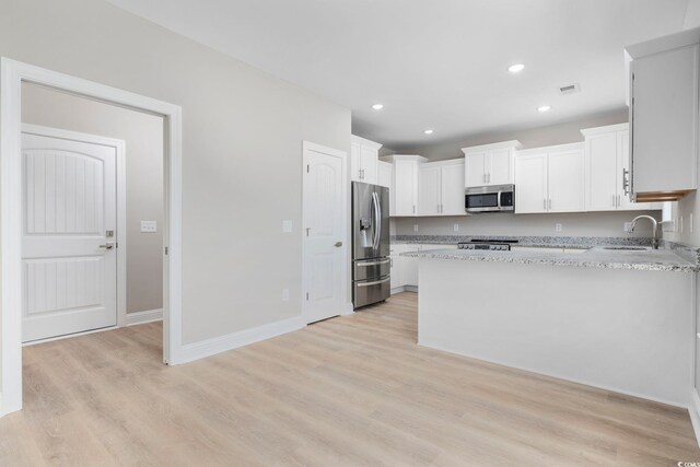 1900 Blue Bird Rd, Loris, SC 29569 - kitchen featuring white cabinets, appliances with stainless steel finishes, a peninsula, light stone counters, and recessed lighting