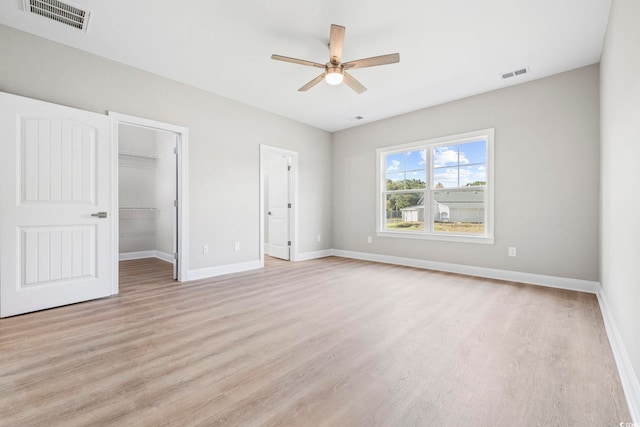 1900 Blue Bird Rd, Loris, SC 29569 - unfurnished bedroom featuring light wood-style flooring, a walk in closet, and a ceiling fan
