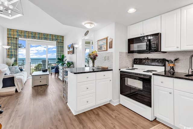2501 S Ocean Blvd Unit 111, Myrtle Beach, SC 29577 - kitchen with range with electric cooktop, black microwave, light wood-style flooring, tasteful backsplash, and recessed lighting