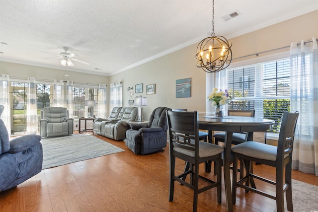 5822 Longwood Dr Unit 104, Murrells Inlet, SC 29576 - dining area featuring a ceiling fan, wood finished floors, a chandelier, crown molding, and a textured ceiling