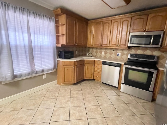 600 65th Ave N Unit 8, Myrtle Beach, SC 29572 - kitchen with appliances with stainless steel finishes, light countertops, decorative backsplash, light tile patterned floors, and a sink
