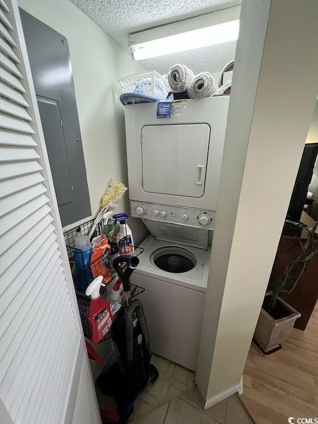 1101 Possum Trot Rd Unit A202, North Myrtle Beach, SC 29582 - laundry room featuring stacked washer / drying machine, electric panel, a textured ceiling, and wood finished floors