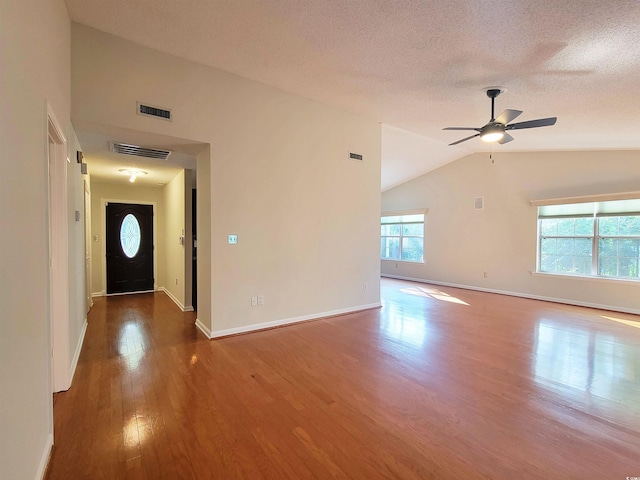 3904 Williamson Cir, Myrtle Beach, SC 29579 - unfurnished living room with wood finished floors, lofted ceiling, a ceiling fan, baseboards, and a textured ceiling