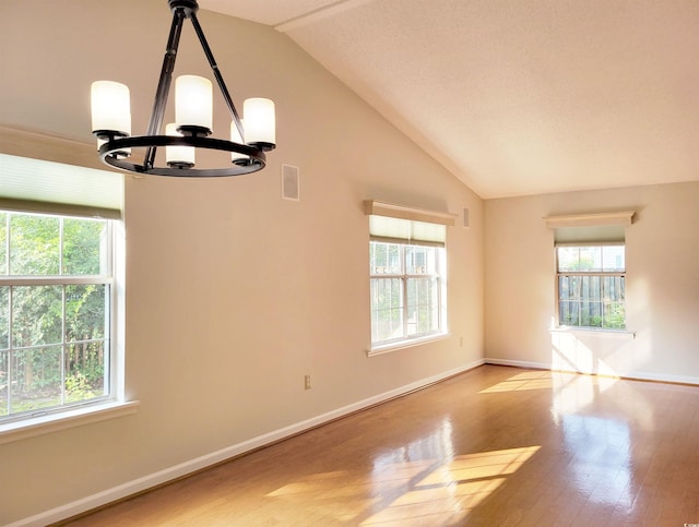 3904 Williamson Cir, Myrtle Beach, SC 29579 - empty room with vaulted ceiling, a chandelier, plenty of natural light, light wood-type flooring, and baseboards